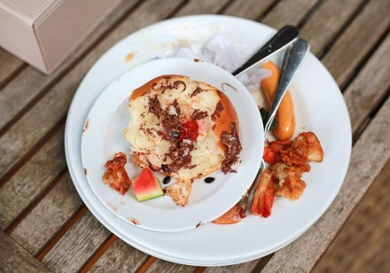 Mehrere halbaufgegessene Speisen auf Tellern übereinandergestapelt