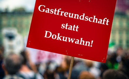 Ein Plakat mit der Aufschrift „Gastfreundschaft statt Dokuwahn!“