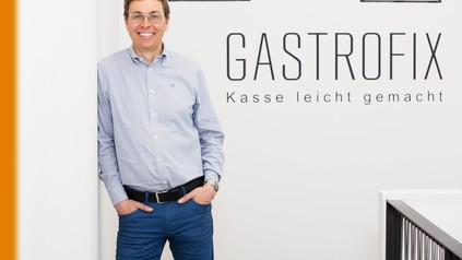 Stefan Brehm steht vor der Aufschrift Gastrofix Kasse leicht gemacht