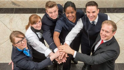 Mitarbeiter des Maritimhotels halten die Hände zusammen als Zeichen der Gemeinschaft