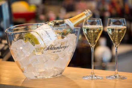 Eine Flasche Schlumberger in einer Schale mit Eis und zwei damit gefüllte Sektgläser