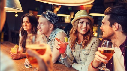 Freunde sitzen an der Bar, trinken und unterhalten sich