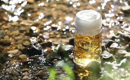 Voller Bierkrug in einem Gewässer