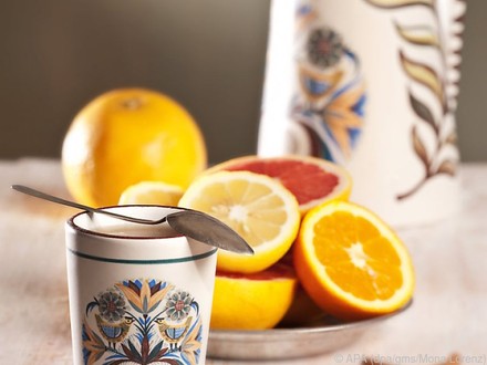 Tasse mit Löffel und Orangenschale im Hintergrund