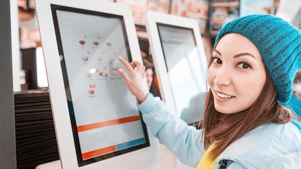 Junge Frau schaut sich Speisen in der digitalen Speisekarte an