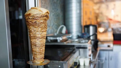 Ein Dönerimbiss mit einem Dönerspieß der noch zur Hälfte mit Fleisch bestückt ist