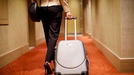 Geschäftsreisende mit Rollkoffer im Hotelflur