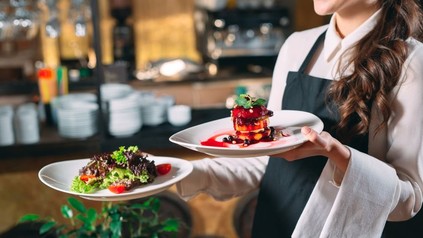 Kellnerin serviert ein Dessert