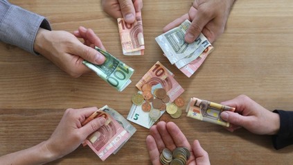 Menschen, die Geldscheine in ihren Händen halten