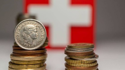 Schweizer Münzen vor Schweizer Wappen