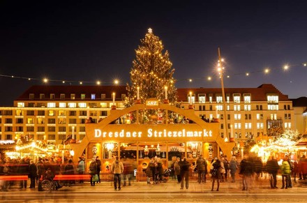 Der Eingang zum Dresdner Striezelmarkt bei Nacht mit vielen Besuchern