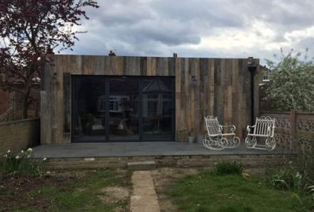 Ein kleines, einstöckiges Gebäude mit zwei Stühlen auf der Veranda