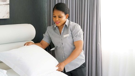 Junge Damen vom Housekeeping schüttelt die Kissen auf