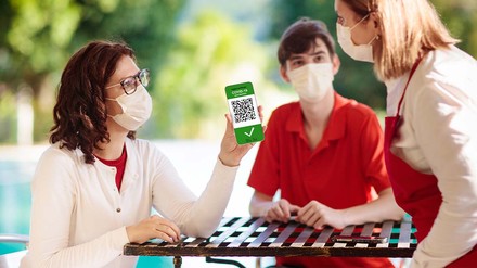 Frau zeigt im Restaurant ihren Impfnachweis vor