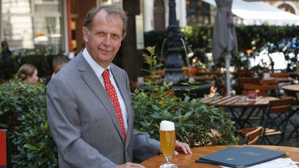 Markus Liebl an einem Tisch im Biergarten vor einem Bier