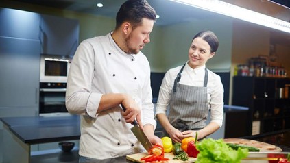 Ein Koch und eine Köchin bei der Arbeit in der Küche