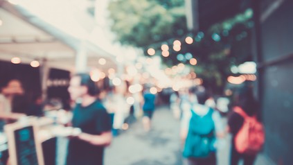 verschwommene Ansicht eines Straßenfestes mit vielen Menschen und Buden/Ständen