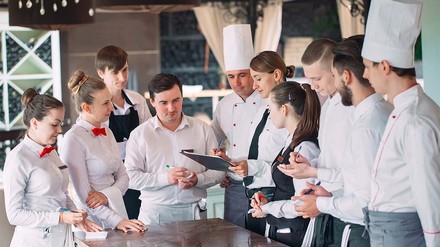 Mitarbeiter eines Restaurants im Gespräch mit der Restaurantleiterin