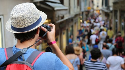Tourist beim Fotografieren einer überfüllten Straße