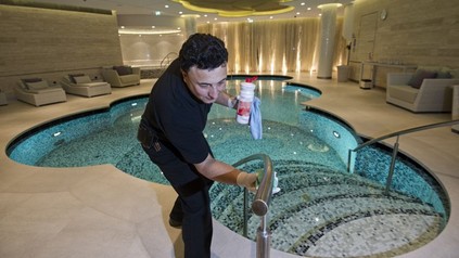 Mann beim Reinigen eines Hotelpools