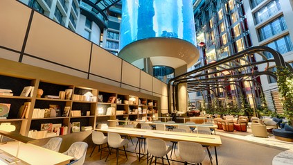 Der AquaDom, eins der größten freistehenden zylindrischen Aquarien der Welt mit 1.600 tropischen Fischen, bleibt das Herzstück der Hotellobby. (Foto: © Radisson Hotel Group)