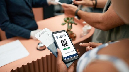 Gast zeigt an der Rezeption seinen Impfnachweis