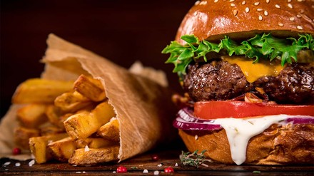 Üppig belegter Burger mit Pommes als Beilage