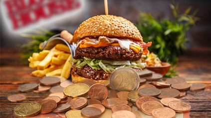 Ein Burger und Pommes vor dem Block House Logo, davor mehrere Cent- und Euromünzen