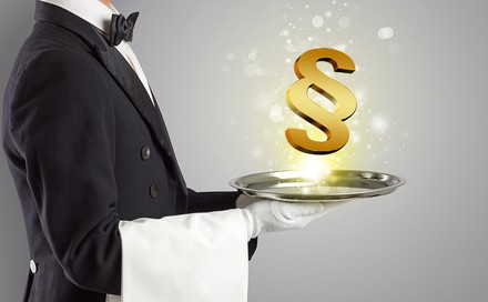 Ein Kellner serviert ein Paragrafenzeichen