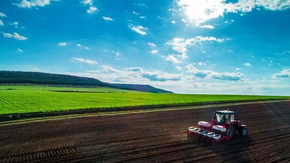 Ein Bauer mit Traktor bei der Arbeit auf dem Feld