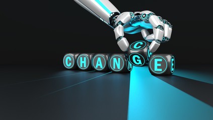 Roboterarm setzt das Wort "Change/Chance"