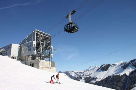 Eine Seilbahn auf einem Berg und zwei Kinder beim Skifahren