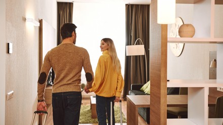 Pärchen betritt Händchen haltend ein Hotelzimmer