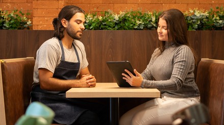 Chefin gibt dem Servicemitarbeiter im Feedbackgespräch Rückmeldung