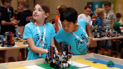 Zwei Kinder basteln an einem Roboter im Rahmen der WRO
