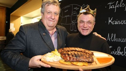 Erich Homolka und Oswald Rössler halten zusammen ein Brett mit Rippchen