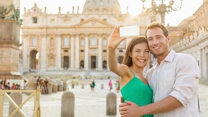 Ein Pärchen macht Fotos vor einer Kirche