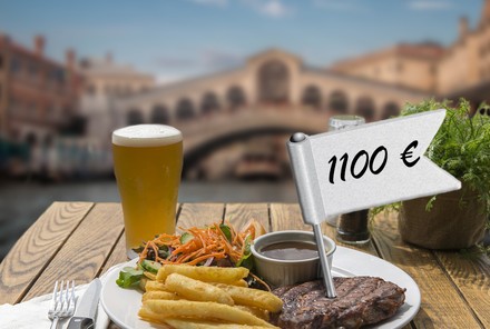 Ein Steak mit Pommes und Salat und ein Glas Bier mit einem Fähnchen auf dem 1100€ steht