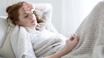 Frau liegt krank im Bett