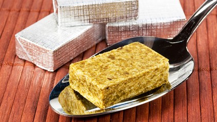 Ein Brühwürfel auf einem Löffel