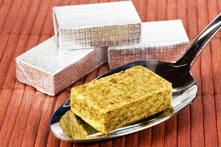 Ein Brühwürfel auf einem Löffel