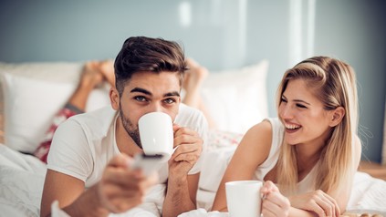 Ein junges Pärchen beim Frühstück im Bett