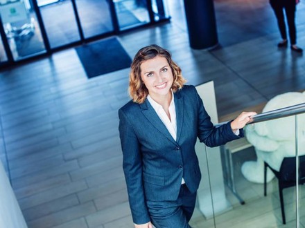 Junge Frau im Businessanzug steigt eine Treppe herauf