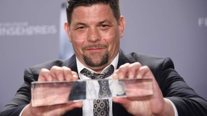 Tim Mälzer mit seinem Preis für Bestes Factual Entertainment