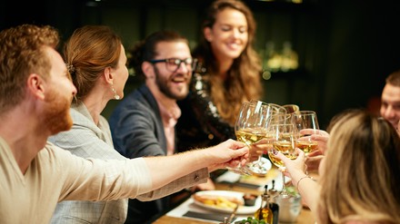 Freunde sitzen im Restaurant und stoßen an