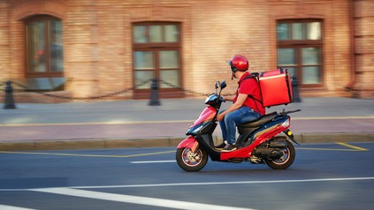 Ein Mitarbeiter eines Food-Lieferdienstes auf dem Motorrad