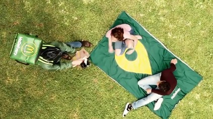 Ein McDonald's-Lieferbote liefert an eine Picknickdecke