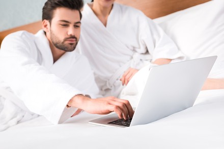 Ein Mann mit einem Laptop im Hotelzimmer