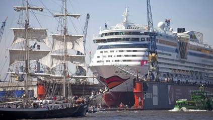 Ein SChiff von AIDA in einem Hafen mit anderen Schiffen