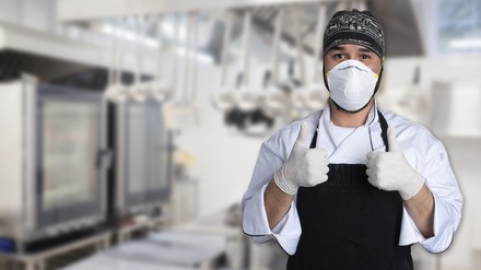 Ein Koch mit Mundschutzmaske